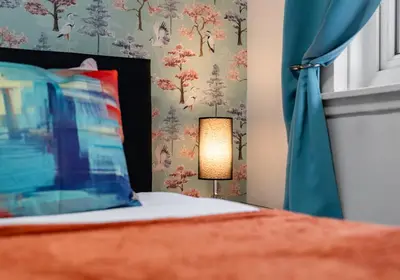 a bedroom with a bed with a blue curtain at Elmbank Avenue House by Klass Living Uddingston in Uddingston