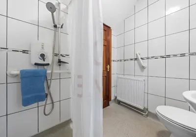 a bathroom with a shower curtain and a toilet at Elmbank Avenue House by Klass Living Uddingston in Uddingston