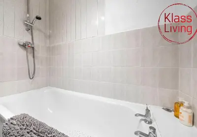 a bathroom with a bath tub and a sink at Elmbank Apartment by Klass Living Bellshill in Bellshill