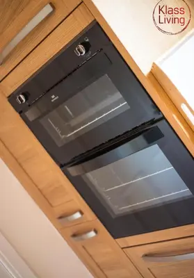 an oven in a kitchen with wooden cabinets at Kenmar House by Klass Living Hamilton in Hamilton
