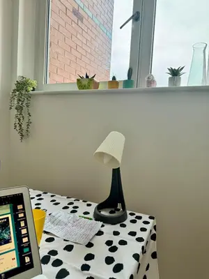 a lamp sitting on a table next to a laptop at Skyline Serenity Cosy Home in Glasgow