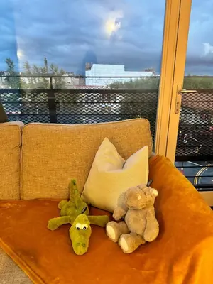 three stuffed animals are sitting on a couch at Skyline Serenity Cosy Home in Glasgow