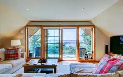 a living room with a couch and a large window at Scone Cottage - Luxury retreat, outstanding views in Craobh Haven