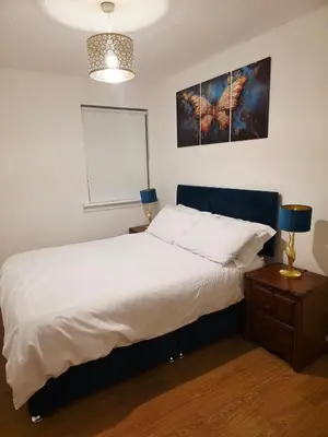 a bedroom with a white bed and two lamps at Cozy 2Bed Flat in Glasgow City Center in Glasgow