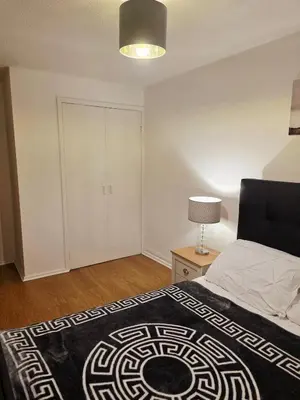 a bedroom with a bed and a white closet at Cozy 2Bed Flat in Glasgow City Center in Glasgow