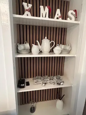 a white shelf with dishes and tea sets on it at Calm of Cumbrae in Millport