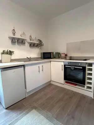 a kitchen with white cabinets and a microwave at Calm of Cumbrae in Millport