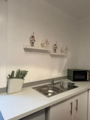 a kitchen counter with a sink and a microwave at Calm of Cumbrae in Millport