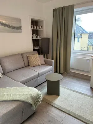 a living room with a couch and a window at Calm of Cumbrae in Millport