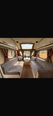 a bus with empty seats and a table in it at 4 berth caravan in Doune
