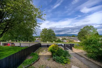 a fence next to a park with a bridge at Stylish Stirling home with stunning views in Stirling