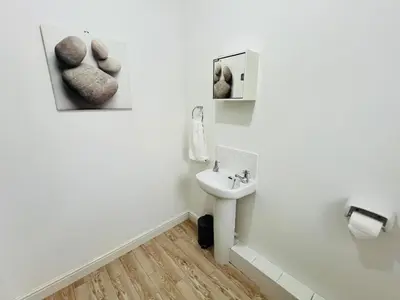 a white bathroom with a sink and a mirror at 3-Bedroom house near Manchester City Centre in Moffat