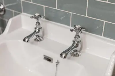 a bathroom sink with two faucets on it at Victorian Apartment - city centre - free car space in Edinburgh