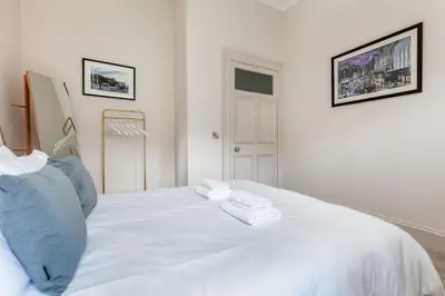 a white bed with two towels on top of it at Victorian Apartment - city centre - free car space in Edinburgh