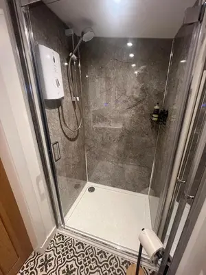 a shower with a glass door in a bathroom at The Wee Bank Hut in Oban
