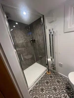 a shower with a glass door in a bathroom at The Wee Bank Hut in Oban