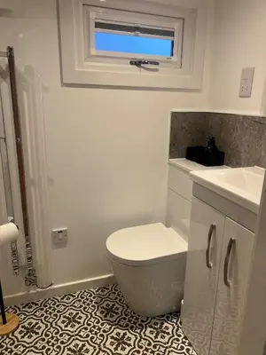 a white bathroom with a toilet and a sink at The Wee Bank Hut in Oban