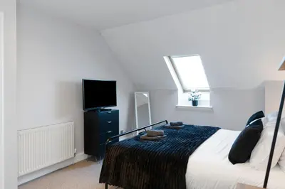 a bedroom with a bed and a flat screen tv at The Clydesider in Glasgow