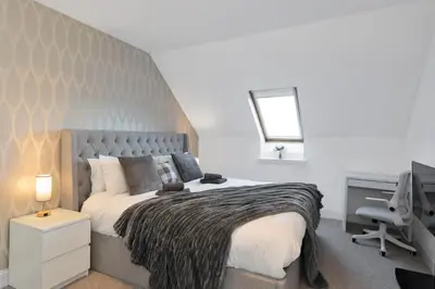 a bedroom with a bed and a desk with a computer at The Clydesider in Glasgow