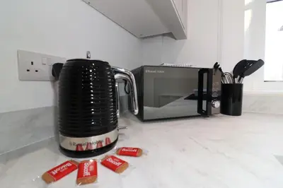 a toaster sitting on a counter next to a microwave at Modern 2 Bedroom Cottage Flat in Stenhousemuir