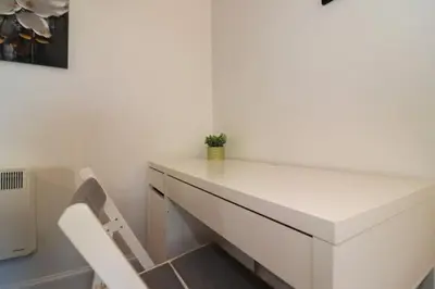 a white desk in a room with a chair at Modern 2 Bedroom Cottage Flat in Stenhousemuir