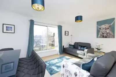 a living room with a couch and a window at Bright 3 Bed Apt overlooking the Clyde SEC & Hydro in Glasgow