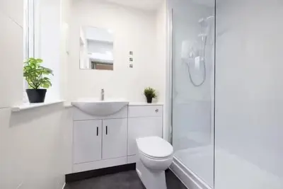 a white bathroom with a toilet and a sink at Bright 3 Bed Apt overlooking the Clyde SEC & Hydro in Glasgow