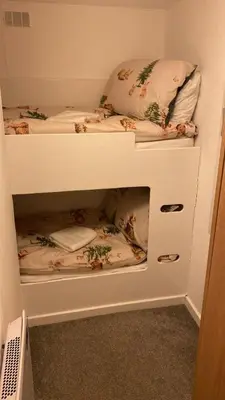 two bunk beds in a small room with ajar at Bethany Woodland Lodge in Winchburgh