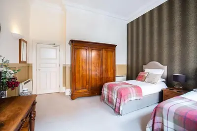 a bedroom with a bed and a dresser and a bed sidx sidx sidx sidx at West George Street Apartment Glasgow in Glasgow