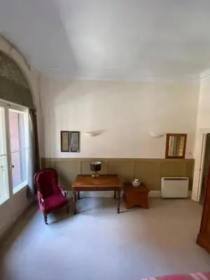 a living room with a table and a red chair at West George Street Apartment Glasgow in Glasgow