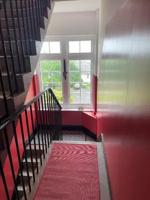 a staircase with a pink carpet and a window at Hidden Gem in Stirling