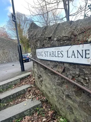 a stone wall with a sign that reads kings stables lane at Hidden Gem in Stirling