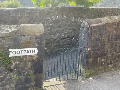 a iron gate with a sign on a stone wall at Hidden Gem in Stirling