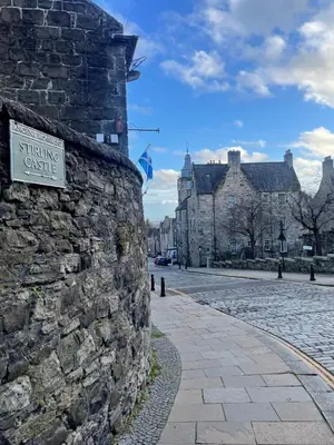 a stone wall with a sign on the side of a street at Hidden Gem in Stirling