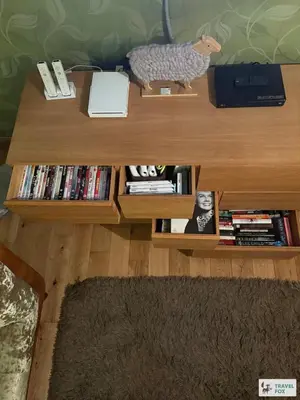 a wooden table with a book shelf with books at Charlotte Street Stay in Port Ellen