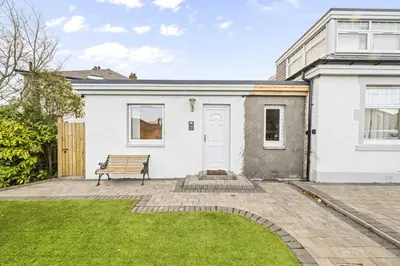 a white house with a bench in the yard at O Hill Crescent 1 Bedroom Studio - Edinburgh in Edinburgh