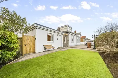 a white house with a bench in a yard at O Hill Crescent 1 Bedroom Studio - Edinburgh in Edinburgh