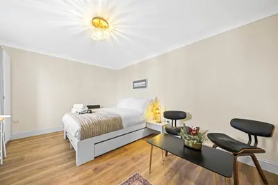 a bedroom with a bed and two chairs and a table at O Hill Crescent 1 Bedroom Studio - Edinburgh in Edinburgh