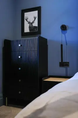 a bedroom with a black dresser and a bed at No 4 Burnbank in Oban