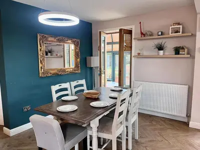 a dining room with a wooden table and chairs at Scottish White House in Edinburgh