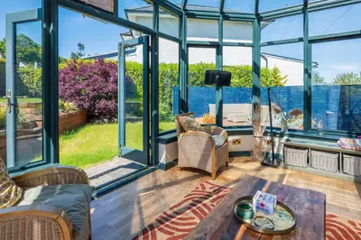 a conservatory with glass doors and a table at Scottish White House in Edinburgh