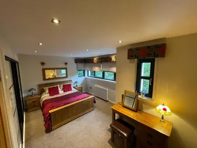a bedroom with a bed and a desk and window at The Loch Lomond Townhouse In The Centre of Balloch in Balloch