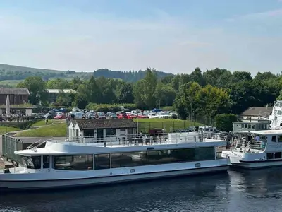 two boats are docked in the water in a harbor at The Loch Lomond Townhouse In The Centre of Balloch in Balloch