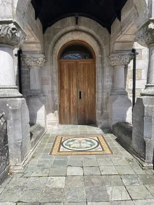 a wooden door in a stone building with a mosaic floor at 6 Lomond Castle - The Inchcruin Suite in Luss