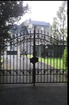 a black wrought iron gate in front of a building at 6 Lomond Castle - The Inchcruin Suite in Luss