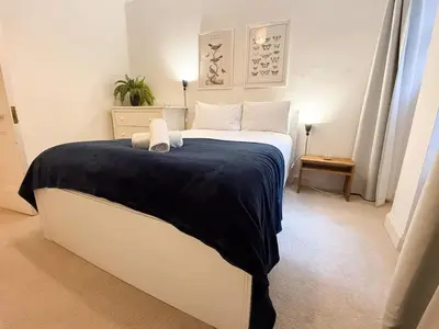 a bedroom with a large bed with a blue blanket at Blantyre Cosy Hideaway in Edinburgh