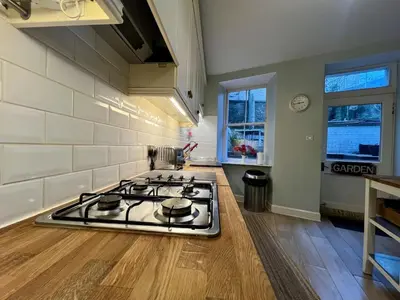 a kitchen with a stove top oven in a room at Blantyre Cosy Hideaway in Edinburgh