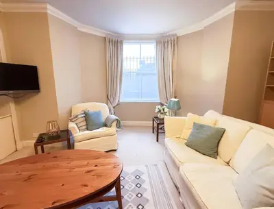 a living room with a white couch and a table at Blantyre Cosy Hideaway in Edinburgh
