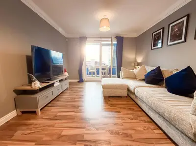 a living room with a couch and a flat screen tv at Riverside 1bd - Balcony & Parking Hydro SECC in Glasgow