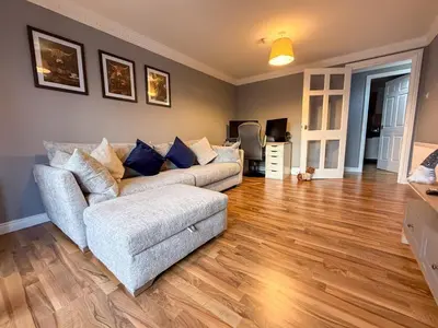 a living room with a couch and blue pillows at Riverside 1bd - Balcony & Parking Hydro SECC in Glasgow